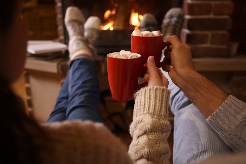 Couple relaxing on the couch with hot chocolate in a cozy, clean home